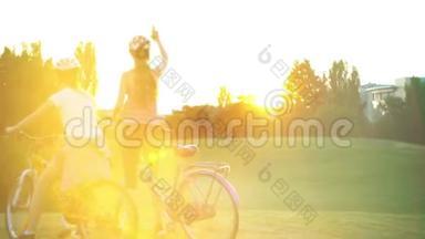 骑自行车的儿童头戴头盔夏季公园太阳升起时敬礼